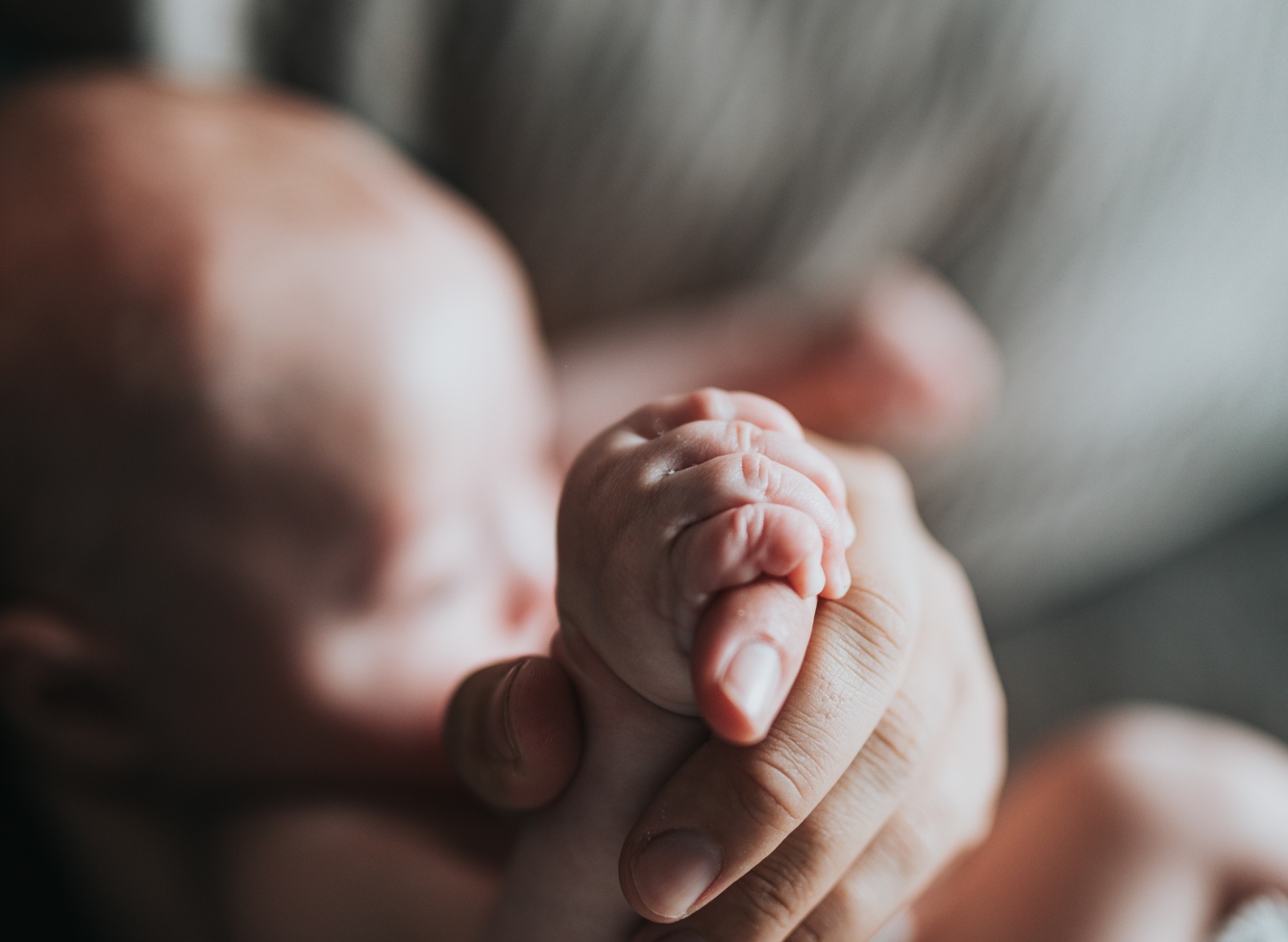 Kūdikis ir mamos ranka laikantį jo ranką