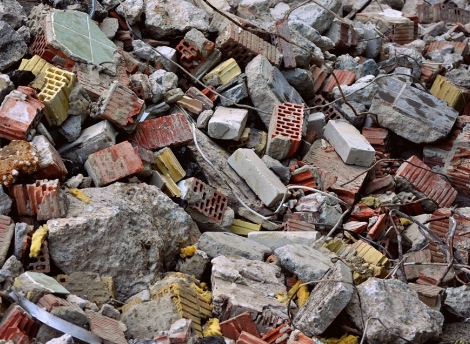 Įvairios statybos ir griovimo atliekos iš arti: plytos, cementas.